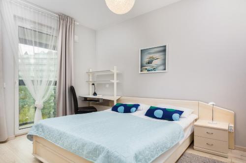 a bedroom with a bed and a desk and a window at Apartments Warsaw Obozowa by Renters in Warsaw