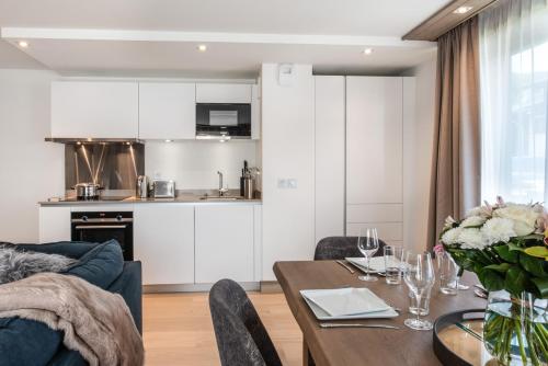 a living room with a table and a kitchen at Annapurna by Alpine Resorts in Les Gets