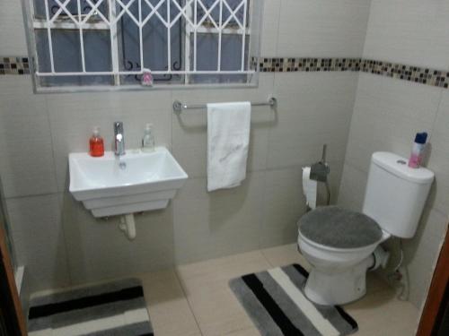 a bathroom with a toilet and a sink at Kingdoms Place Guesthouse in Ga-Luka