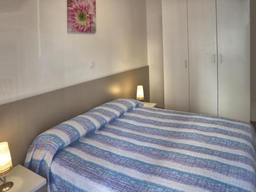 リニャーノ・サッビアドーロにあるLucernaのベッドルーム1室(青いストライプの毛布付きのベッド1台付)