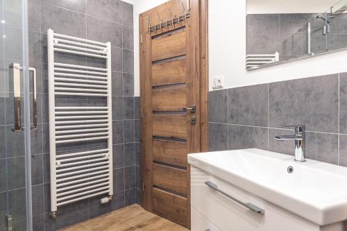 y baño con lavabo y ducha. en TATRYSTAY Tatrahouse Luxury Apartment, en Stará Lesná