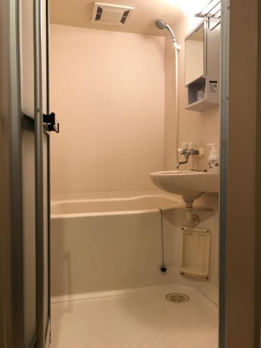 Oarai Hotel Annex Gyoraian في واراي: حمام صغير مع حوض ومرحاض