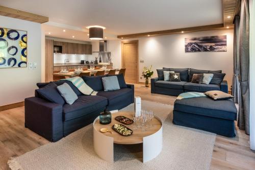 a living room with two blue couches and a table at Annapurna by Alpine Resorts in Les Gets