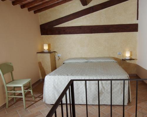 a bedroom with a bed and a chair at Bacco a Petroio in Vinci