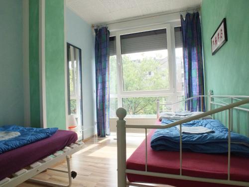 a bedroom with two bunk beds and a window at Max Hostel in Bonn