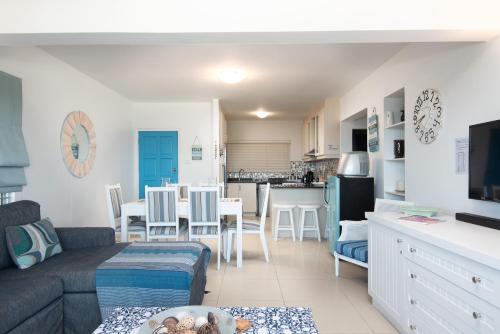 a living room with a couch and a kitchen at Pebble Beach 1 in Ballito