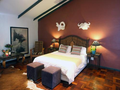a bedroom with a large white bed with two stools at Marianne Wine Estate in Stellenbosch