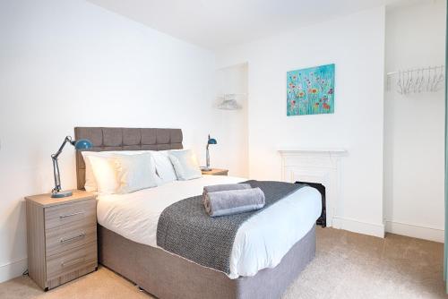 a bedroom with a king sized bed with a night stand at Spacious 4BR Home with Garden, Swansea in Swansea
