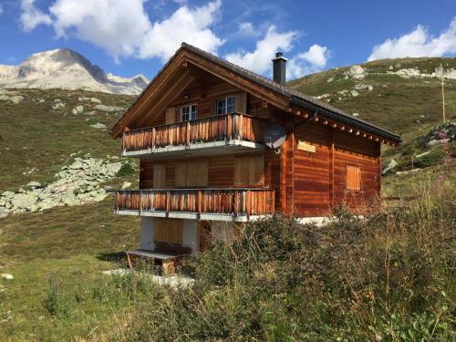 a wooden house on a hill with mountains in the background at Farfalla in Blatten bei Naters