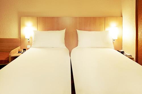 Una cama o camas en una habitación de Ibis Évry-Courcouronnes