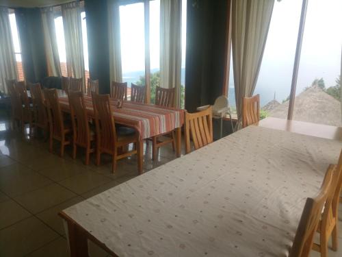a dining room with a table and chairs and windows at Kilima Resort in Iten