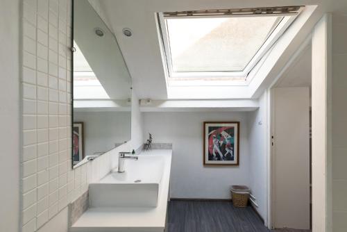 La salle de bains est pourvue d'un lavabo et d'une lucarne. dans l'établissement Biarritz Pays Basque - Maison Lucie, à Biarritz