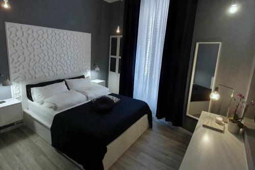 Schlafzimmer mit einem schwarzen und weißen Bett und einem Spiegel in der Unterkunft ALTIDO Heart of the City 1 Bed Apt near Castle Belvedere in Genua