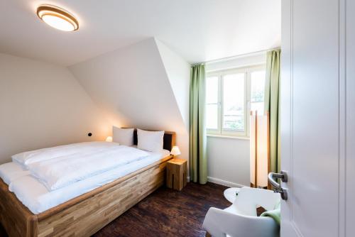 ein kleines Schlafzimmer mit einem Bett und einem Fenster in der Unterkunft Zum fröhlichen Tagelöhner in Quedlinburg