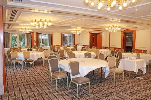 a banquet room with white tables and chairs and chandeliers at Fredrick's Hotel Restaurant Spa in Maidenhead