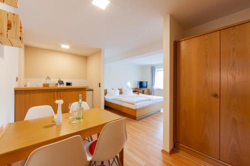 a room with a table and chairs and a bed at Appartementhaus EifelAdventures in Berlingen