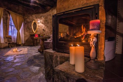 a living room with a fireplace and two candles at Royal Valentina Castle in Ognyanovo