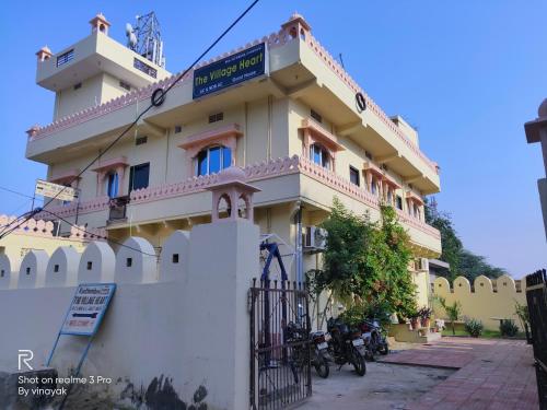 un bâtiment avec des motos garées devant lui dans l'établissement Hotel The Village Heart, à Sawai Madhopur