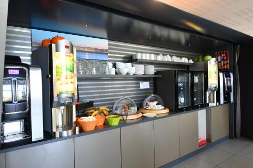 een koffiebar met een bar met eten en drinken bij Appart-Hôtel Mer & Golf City Bordeaux - Bruges in Bruges