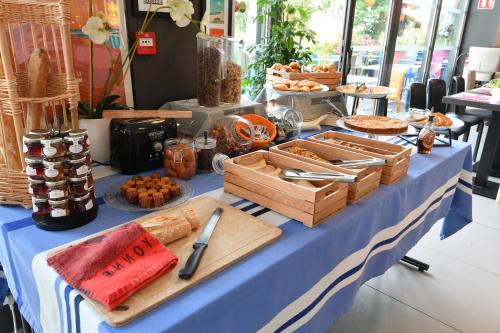 een tafel met een blauwe tafeldoek met voedsel erop bij Appart-Hôtel Mer & Golf City Bordeaux - Bruges in Bruges