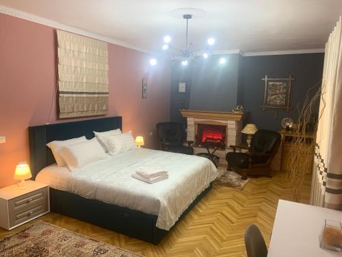 a bedroom with a large bed and a fireplace at BELUX HOTEL in Tirana
