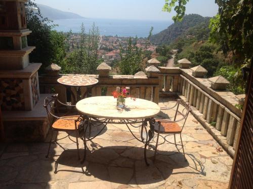 a table and chairs on a balcony with a view at Villa Symbola in Oludeniz