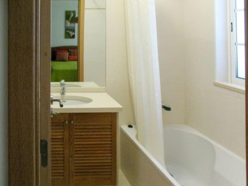 ein Badezimmer mit einem Waschbecken, einer Badewanne und einer Badewanne in der Unterkunft Vivenda Carioca in Vila Nova De Cacela