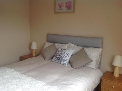 a bedroom with a white bed with pillows on it at The Rock Equestrian Farm B&B in Bailieborough