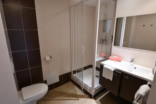 une salle de bain avec une douche, des toilettes et un lavabo dans l'établissement Appart-Hôtel Mer & Golf City Bordeaux - Bruges, à Bruges