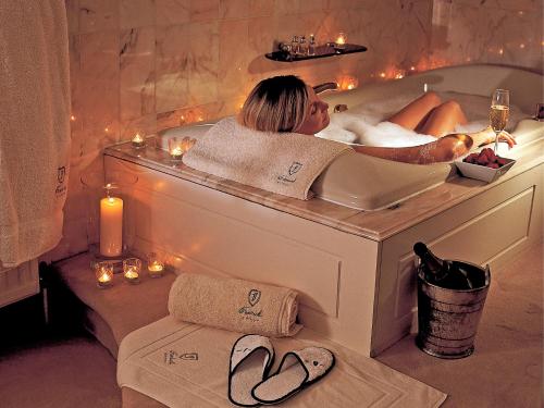 - une femme dans une salle de bains pourvue d'une baignoire dans l'établissement Fredrick's Hotel Restaurant Spa, à Maidenhead