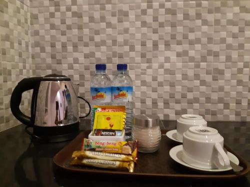 a table with a tea kettle and bottles of water at Bis homestay in Sumbawa Besar