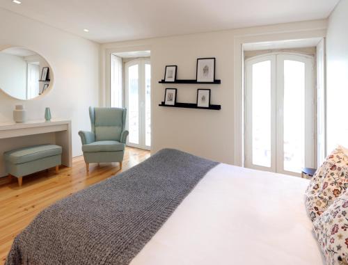 una camera con letto e sedia di HM - Charming Pinheiro Duplex Apartment a Porto