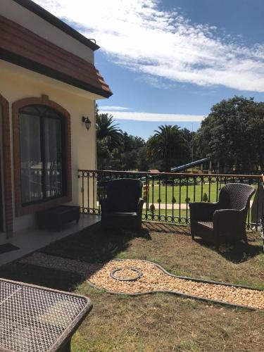 a wrought iron fence with two chairs and a table at Hotel & Glamping Huasca Sierra Verde in Huasca de Ocampo