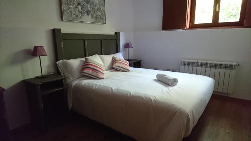 a bedroom with a white bed with a pillow on it at MARGASOL in Pedrezuela