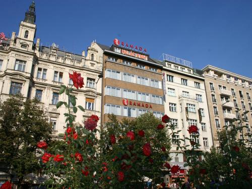 een groot gebouw met rode bloemen ervoor bij Ramada Prague City Centre in Praag