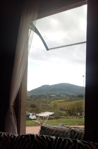 a window with a view of a field and a plane at Suite Bobo relax nel chianti classico gallo nero in Strada