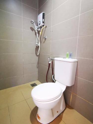 a bathroom with a toilet with a phone on the wall at Clover Hotel Port Dickson in Port Dickson