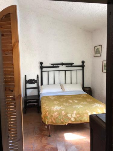 1 dormitorio con 1 cama y 1 silla en Torretta del Sordo Lago di Bolsena, en Piansano