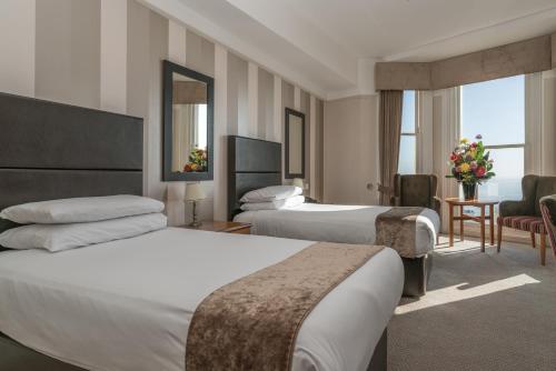 a hotel room with two beds and a living room at Queens Hotel & Spa in Brighton & Hove