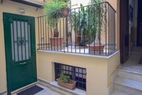 een groene deur met potplanten aan de zijkant van een gebouw bij Millimetro in Palermo