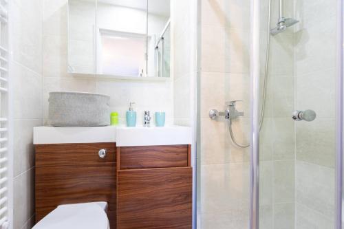 a bathroom with a sink and a shower at Chic Studio Flat in West Kilburn near Queen's Park in London