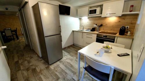 a small kitchen with a table and a refrigerator at "LE TRAMWAY" Appartement 150m gare des Aubrais in Fleury-les-Aubrais