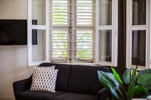 a couch sitting in a living room with windows at Boutique Hotel 't Klooster in Willemstad