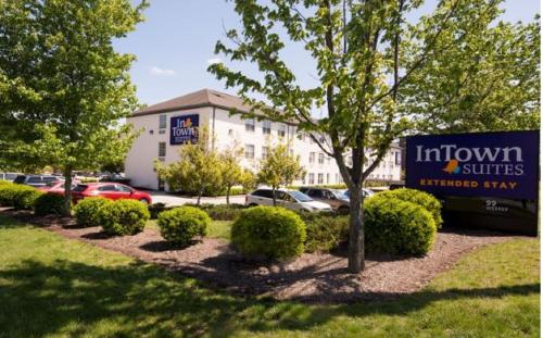 a building with cars parked in a parking lot at InTown Suites Extended Stay Greensboro NC - Airport in Greensboro