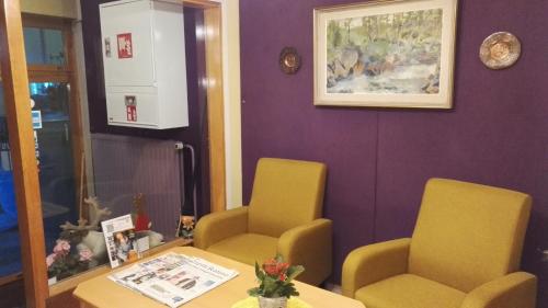 a waiting room with two yellow chairs and a table at Guesthouse Outa in Rovaniemi