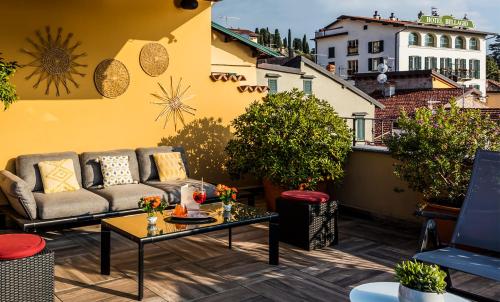 a patio with a couch and a table on a balcony at Hotel Du Lac & SPA in Bellagio