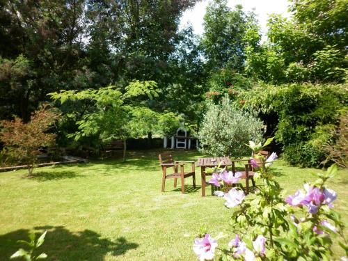 a picnic table and chairs in a yard with flowers at Las Navedas in Santibáñez de Villacarriedo