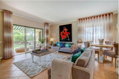 a living room with a couch and a table at Gramacho Golf Bungalow private garden and terrace shared pool in Carvoeiro