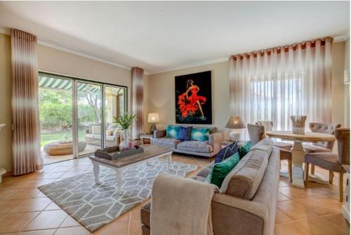 uma sala de estar com um sofá e uma mesa em 2bedroom bungalow on Gramacho Golf Resort heated shared pool em Carvoeiro