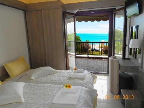 - une chambre avec un lit et une vue sur l'océan dans l'établissement Karali Studios, à Nikiti